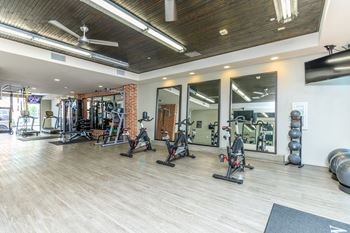 A gym with a variety of equipment including treadmills, weights, and exercise machines.